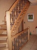 Aufgesattelte Treppe in Buche massiv mit Geländerstäben in Holz und Edelstahl